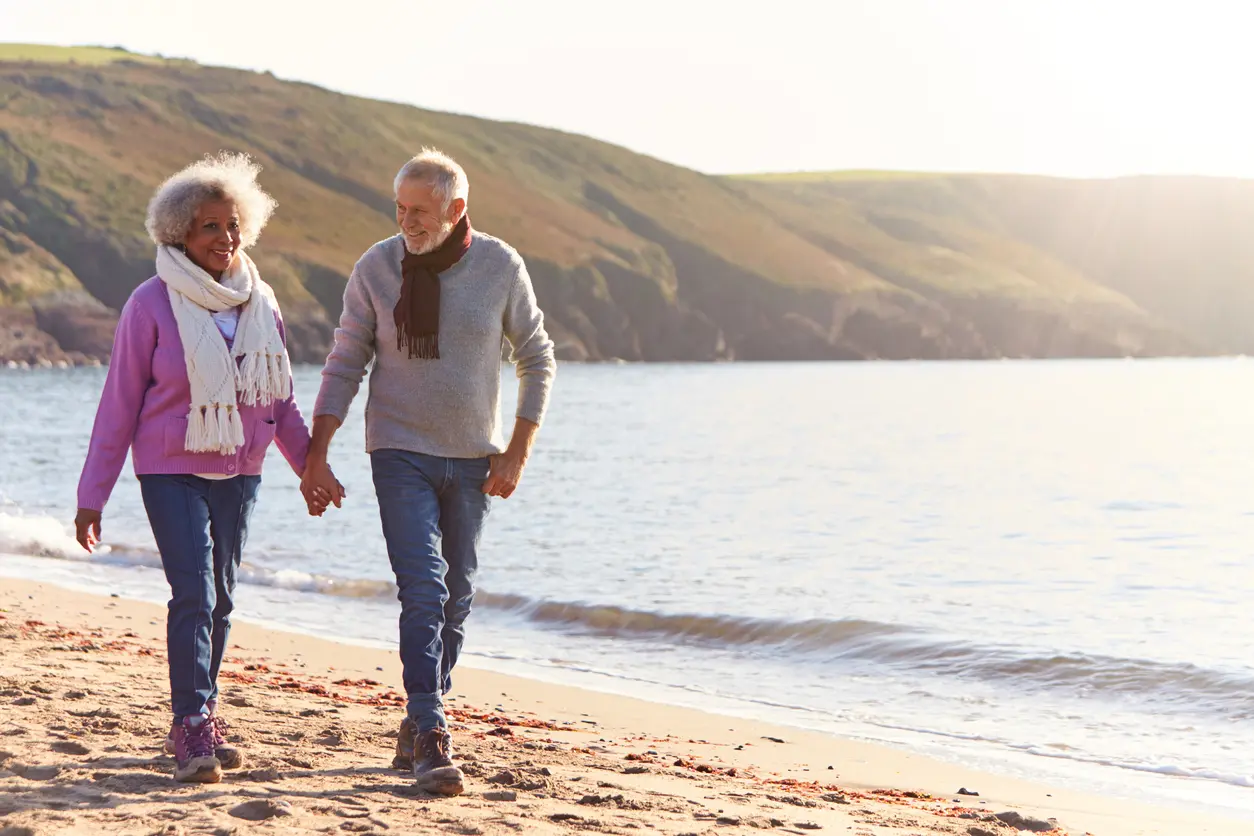 Senior couple walking together on beach
