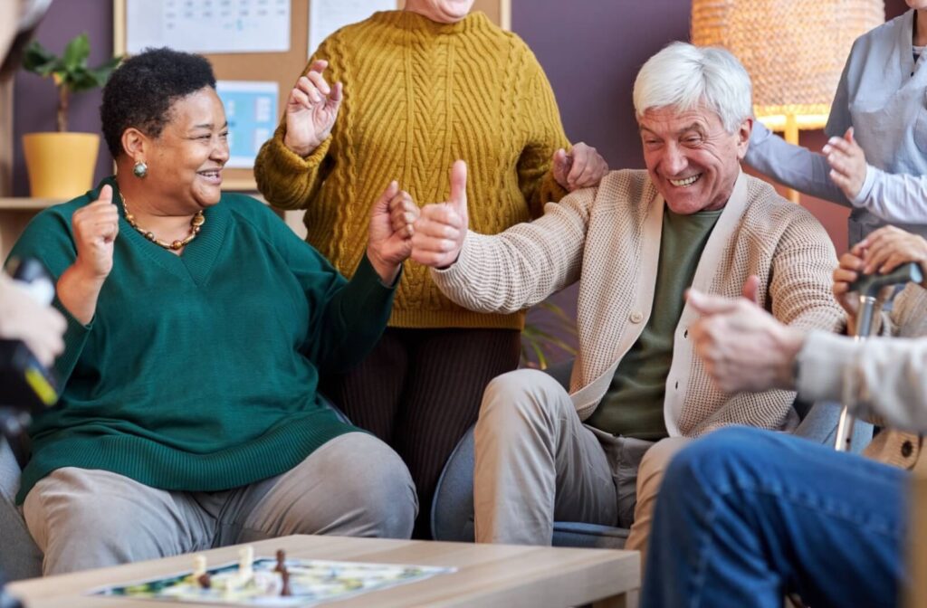 two seniors celebrate while playing a board game
