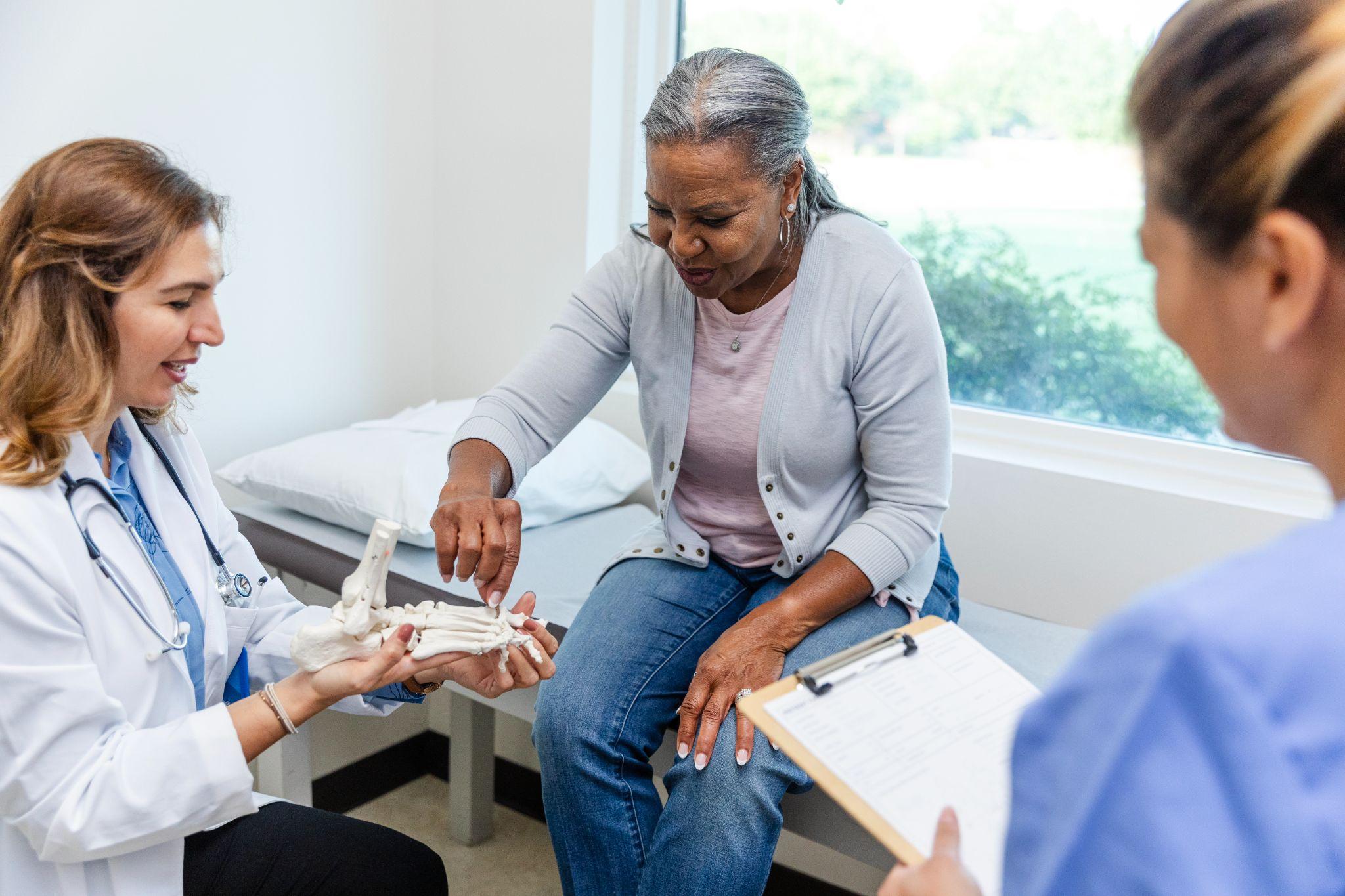 An older woman visits a doctor regarding her bone health.